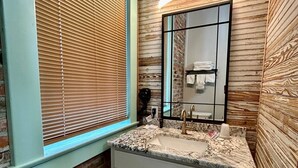 A bathroom with a window, a sink with a mirror, and a towel rack. - Room 6 (sleeps 2) at Chipley's Squareview Inn (Carthage)