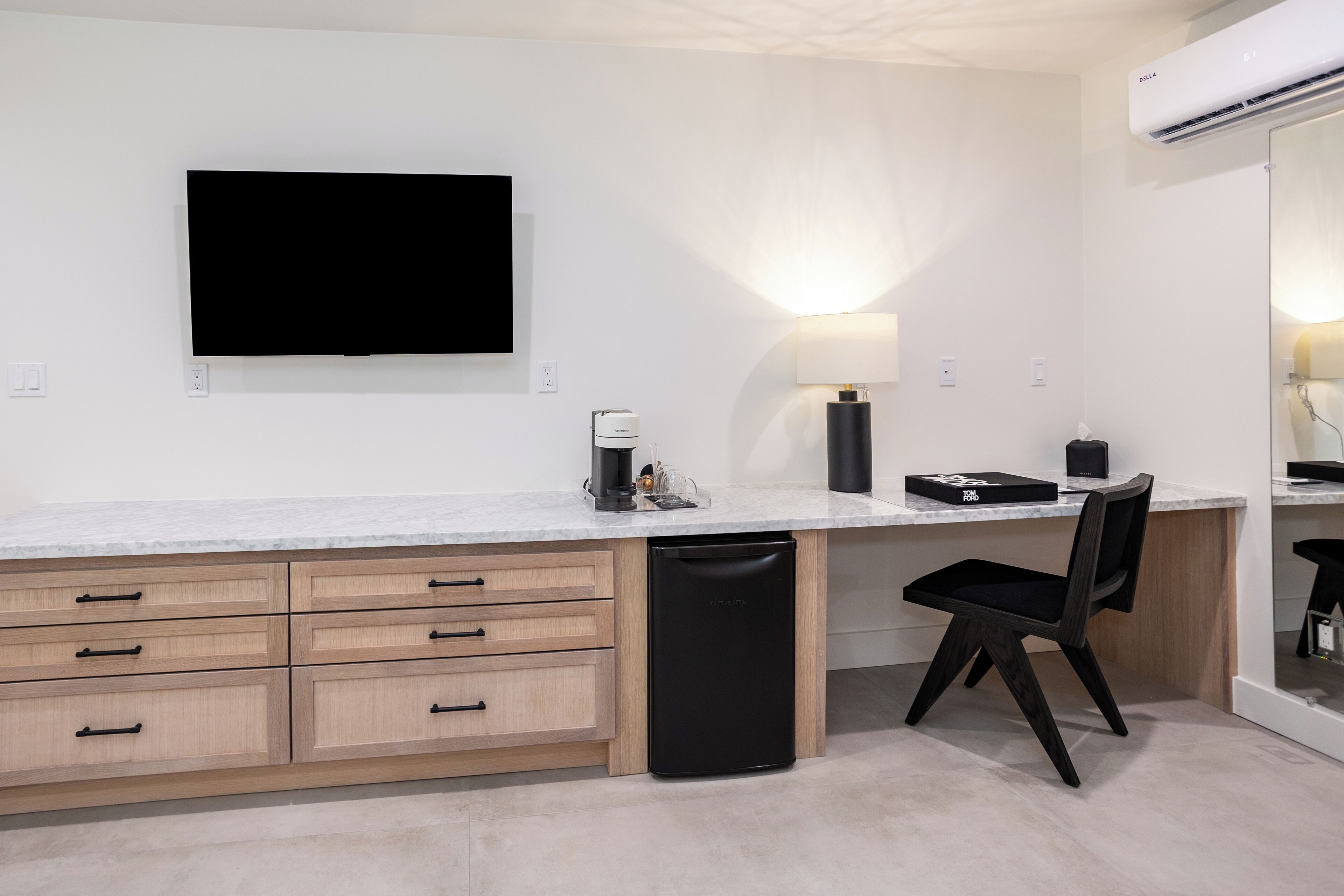 A modern kitchen with a built-in dishwasher, a flat-screen TV, and a coffee maker.