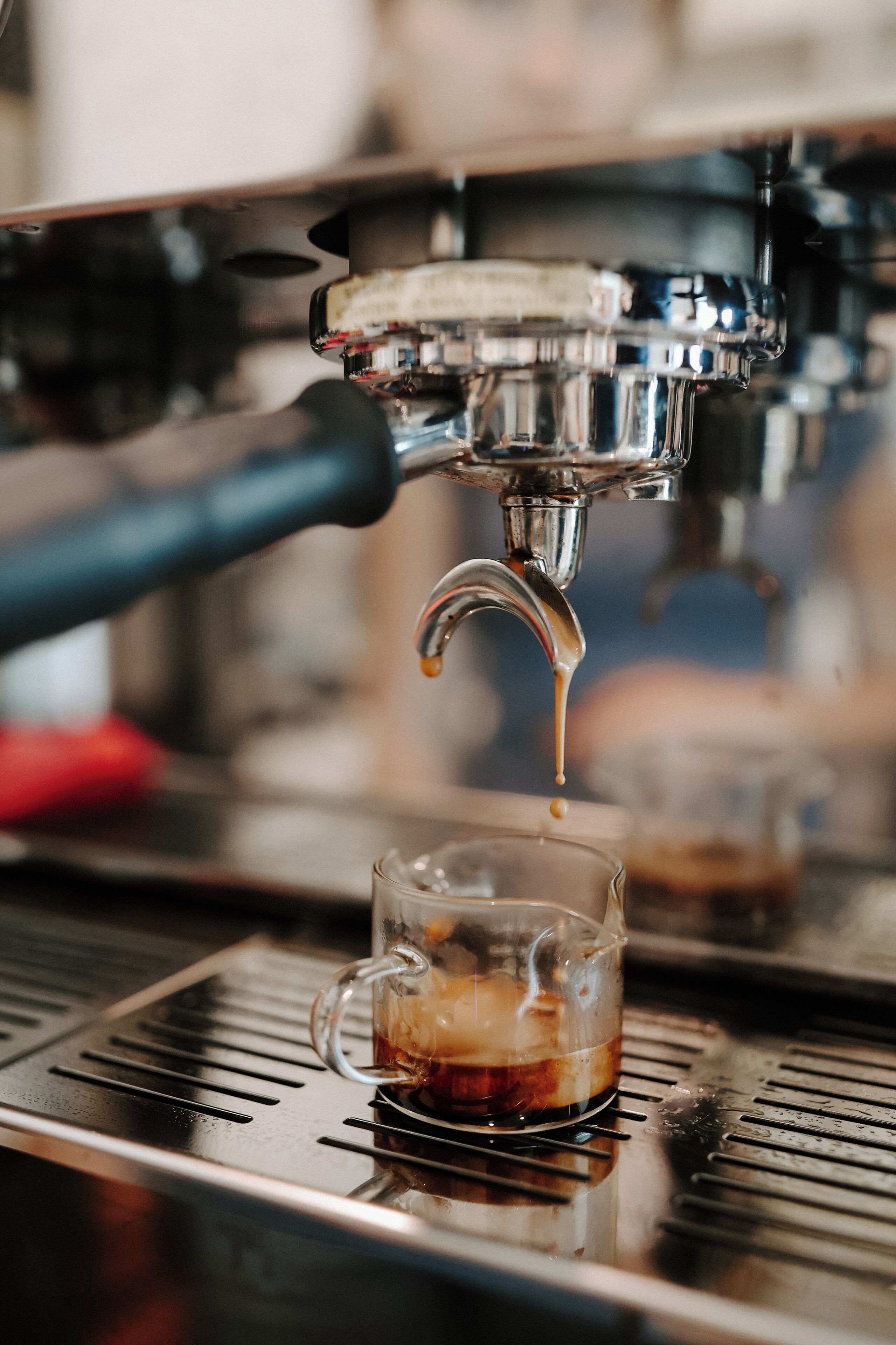Een koffieapparaat schenkt koffie in een glazen beker.