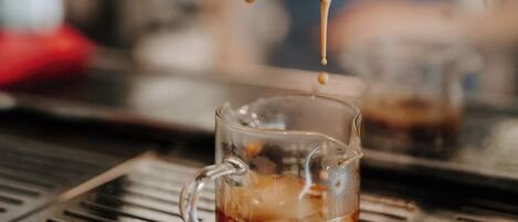 A coffee machine dispensing coffee into a glass cup.