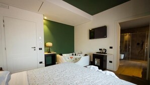 Een hotelkamer met een groot bed, een badkuip, een wastafel en een douche.