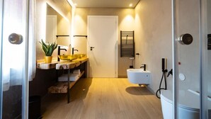 Een moderne badkamer met een houten wastafel, een wasbak, een spiegel en een handdoekrek.