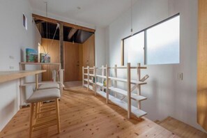 Een modern interieur met houten vloeren, een witte bank en een boekenkast.