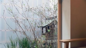 Une pièce donnant sur un jardin japonais traditionnel, avec une porte vitrée.