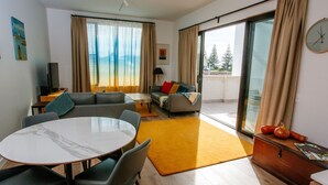 A modern living room with a marble dining table, grey sofas, and a yellow rug. - Welcome to Whale Song (Middleton Beach)