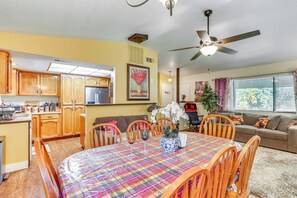 A spacious living area with a dining table, chairs, a sofa, and a kitchen in the background. - Hot Tub, Dog-Friendly Yard! 3-Acre Redding Retreat (Redding)