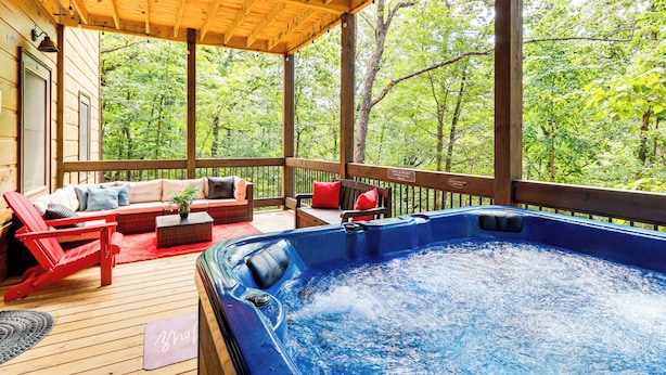A wooden deck with a hot tub, red chairs, and a sofa with cushions. - 'Next Stop Heaven' Game Room & Multiple Decks (Ellijay)