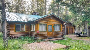 Eine rustikale Holzhütte mit Metalldach, Holzboden und einer kleinen Veranda.