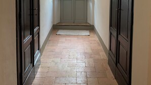 A hallway with a tiled floor, a green pendant light, and two doors on either side.