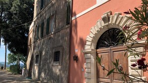 A building with a stone facade, a wooden door with a wrought iron gate, and a sign indicating a room number.