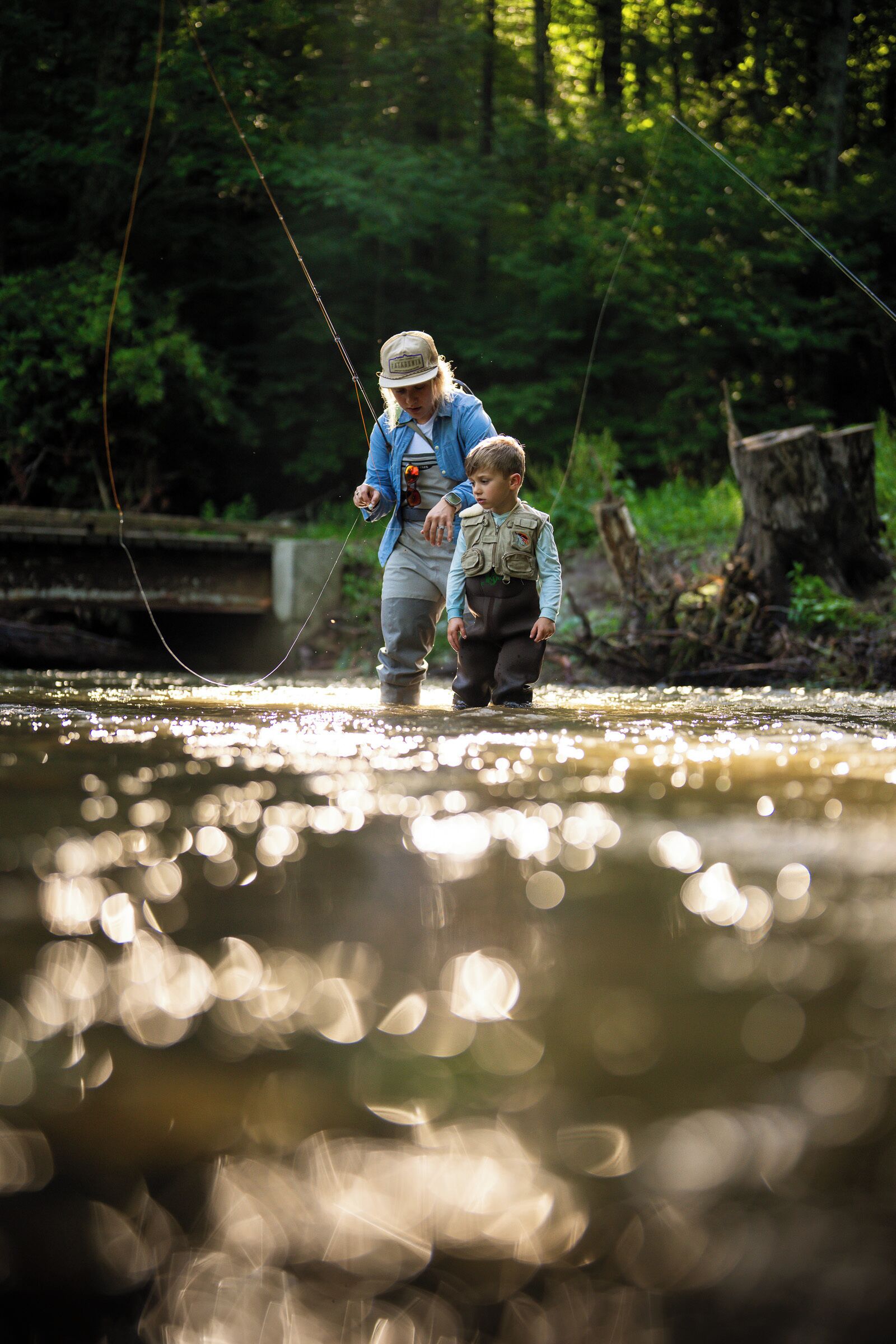 A person standing in a river with another individual nearby.