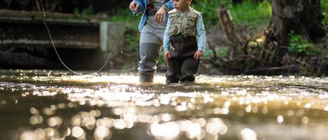 A person standing in a river with another individual nearby.