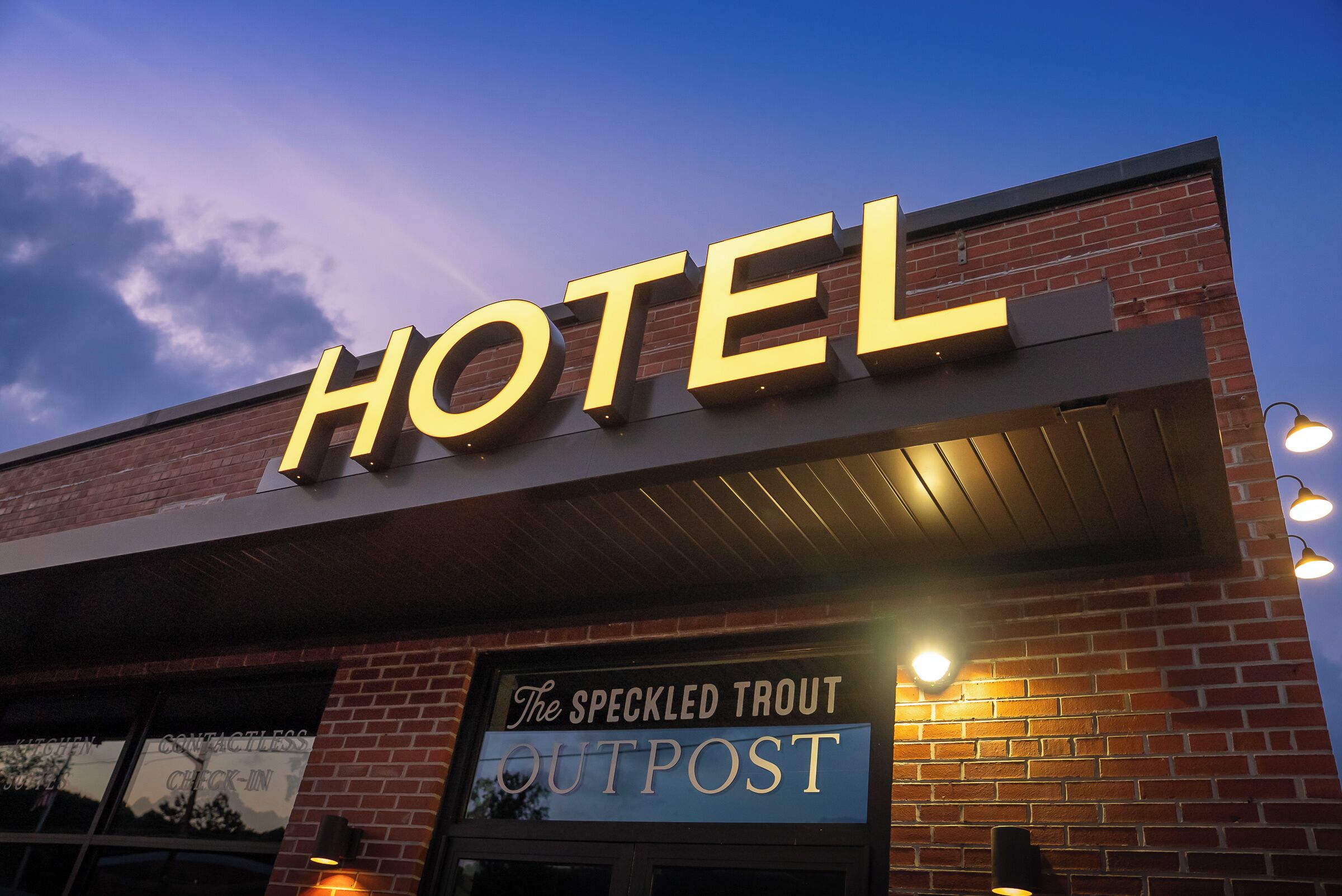 A hotel sign with 'HOTEL' in large letters and 'The Speckled Trout Outpost' below.
