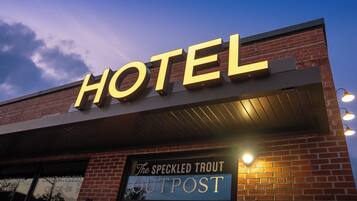 A hotel sign with 'HOTEL' in large letters and 'The Speckled Trout Outpost' below.