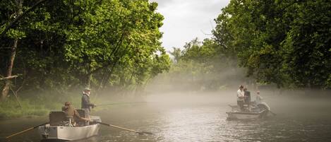 Two boats on a river surrounded by dense greenery.