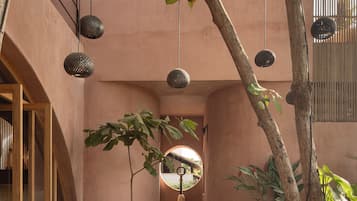 Un patio con área de descanso, luces colgantes y un árbol.