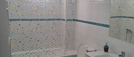 Un baño con inodoro, lavamanos y ducha.