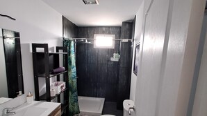 Un baño moderno con tocador de madera, una bañera y un inodoro.