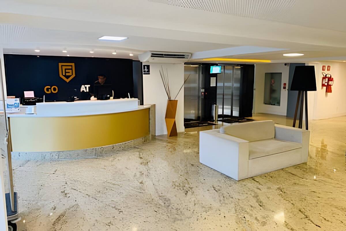 A reception area with a curved counter, a seating area, and a glass door leading to another room.