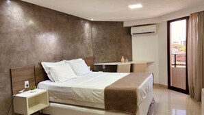 Una habitación de hotel moderna con una cama, una mesita de noche y un escritorio con una silla.