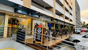 Un edificio de varios pisos con un diseño moderno, que cuenta con locales comerciales en la planta baja y unidades residenciales u oficinas en los pisos superiores.