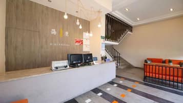 A reception area with a desk, computers, and a staircase.
