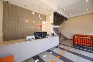 Zona de recepción con un mostrador, computadoras y una escalera.
