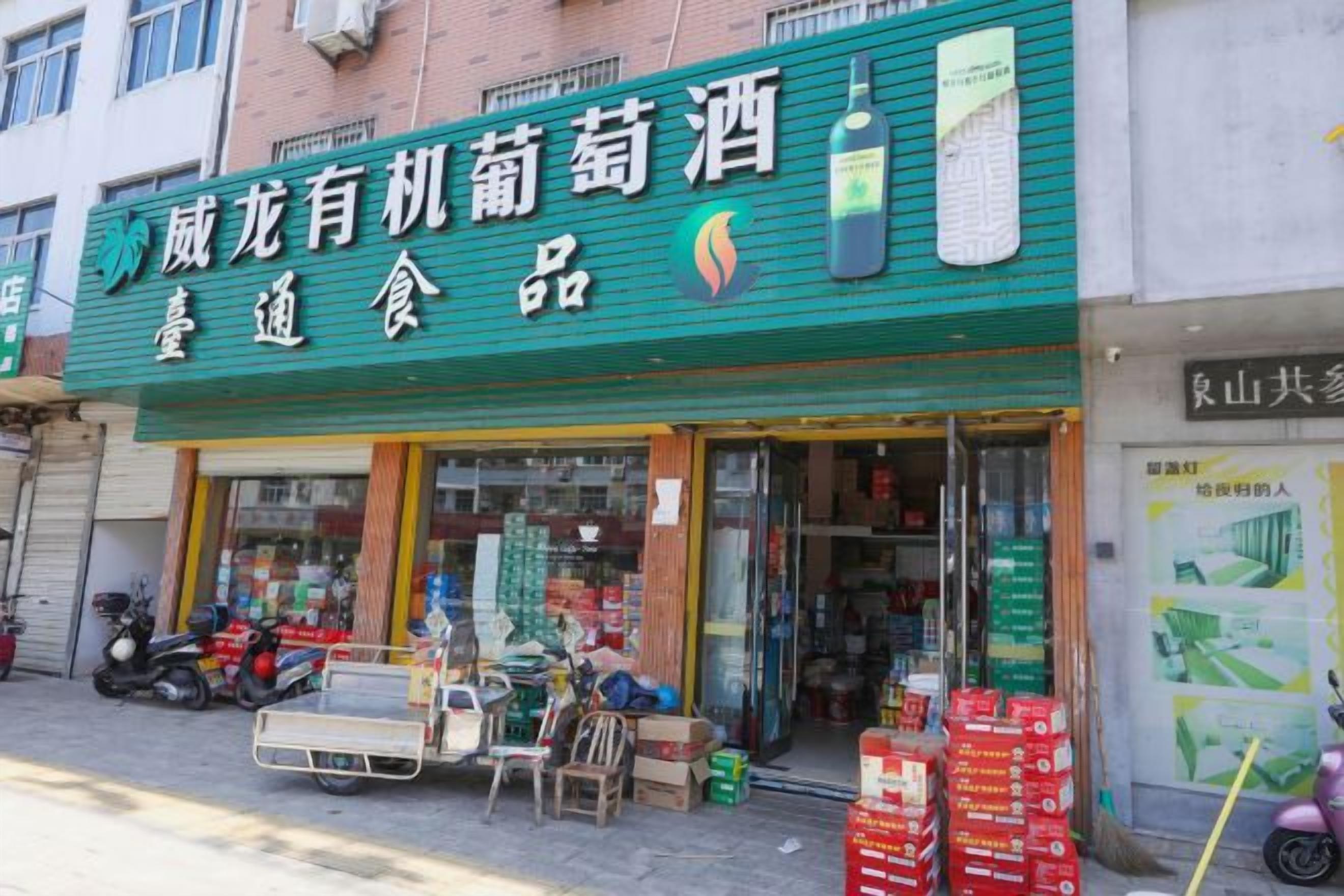 A storefront with a green awning and a signboard.