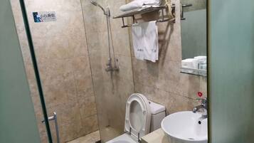 Ein Badezimmer mit Dusche, Toilette und Waschbecken.