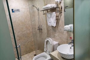 Un baño con ducha, inodoro y lavamanos.