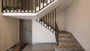 A staircase with a handrail and a door at the bottom.
