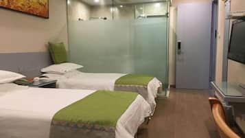 Quarto de hotel com duas camas, chuveiro, televisão e uma porta.
