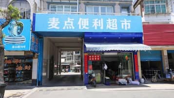 A storefront with a blue awning and a sign in a foreign script.