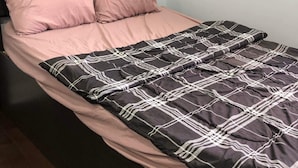A bed with a dark headboard, two pink pillows, and a black and white checkered bedspread. - Shay-203-Cozy Holiday Room (Pickering)
