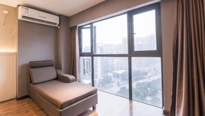 A modern room with a sofa, large windows, and an air conditioning unit. - Cangzhou Maiji Fashion Chain Hotel (Chenzhou)