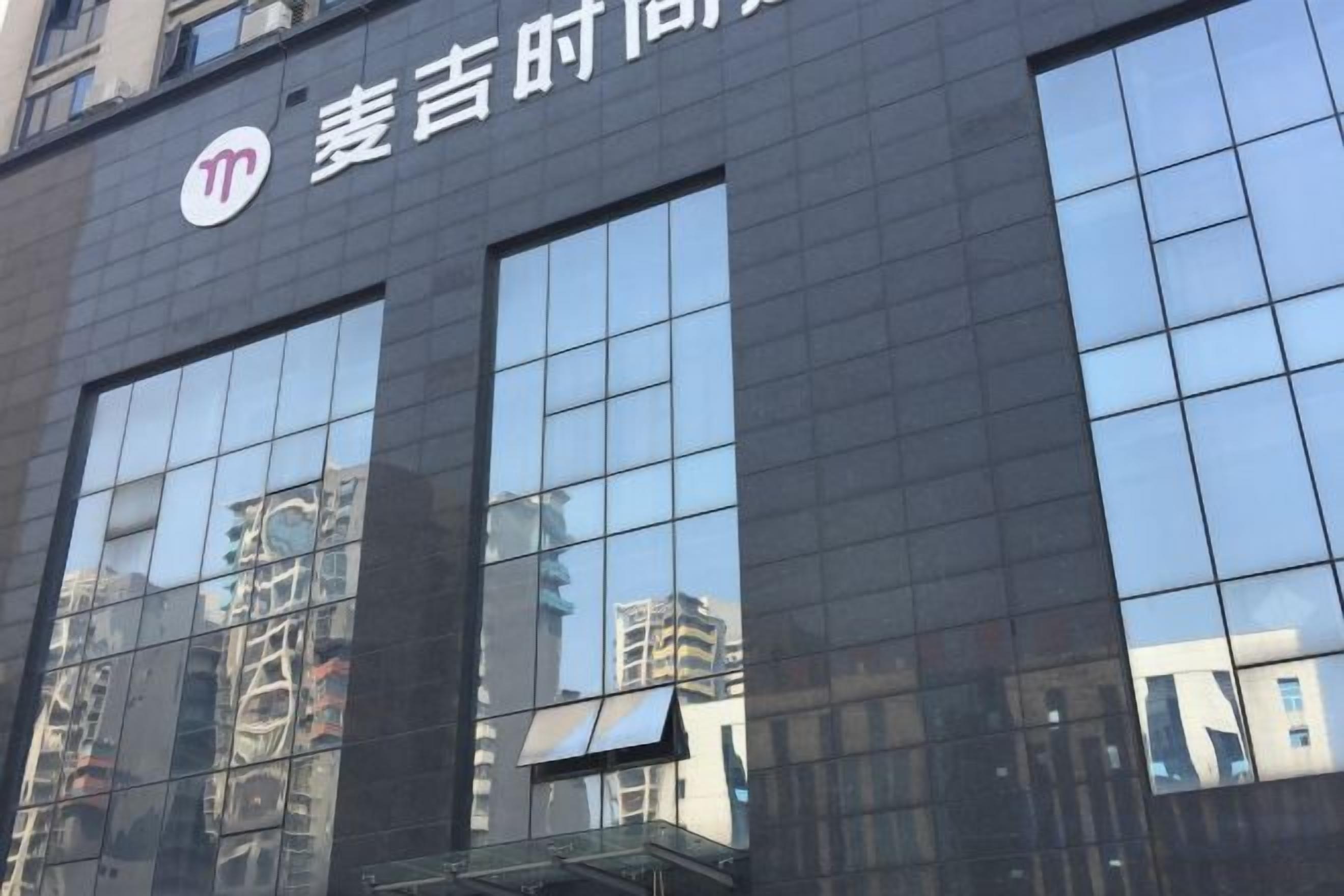 A building facade with large reflective windows and a logo.