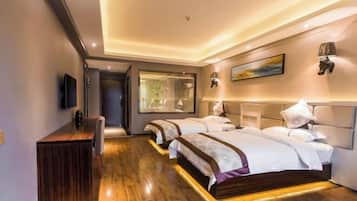 A hotel room with two beds, a desk, a TV, and a large window.