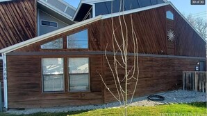 A modern house with a sloped roof, large windows, and a wooden exterior. - DT Boise Townhome near BSU (Boise)
