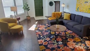 A living room with a sofa, armchair, coffee table, and a floral rug. - DT Boise Townhome near BSU (Boise)