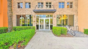A building with a brick facade, large windows, and a sign with letters 'GM'. - Beautifully RENOVATED 3 Bed/2.5 Bath Condo with ALL King beds in Ole at Lely!  (Naples)