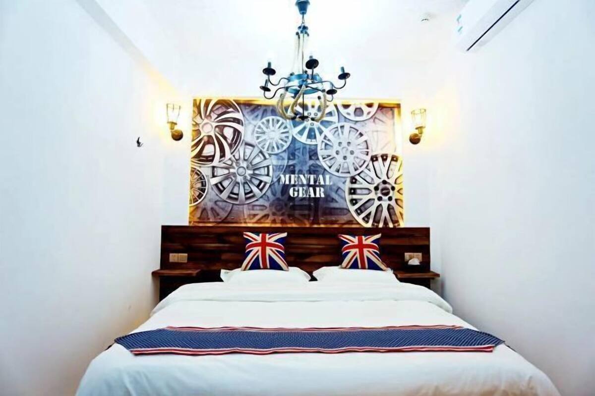 A bedroom with a bed, a chandelier, a wall with a wheel design, and a sign that reads 'MENTAL GEAR.'