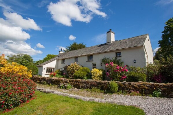 A white house with a stone wall and a gravel path. - Old Droomer (Windermere)