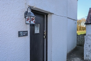 Egy ajtó, amelyen egy „Oscar's Pad” feliratú tábla található, és felette egy díszes lámpa.