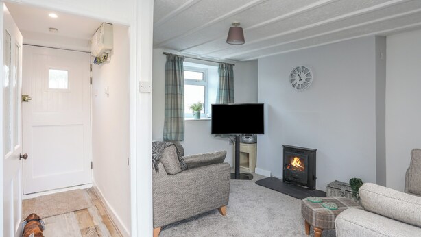 A cozy living room with a fireplace, a television, and a sofa. - Oscar's Pad (Llanfairpwllgwyngyll)
