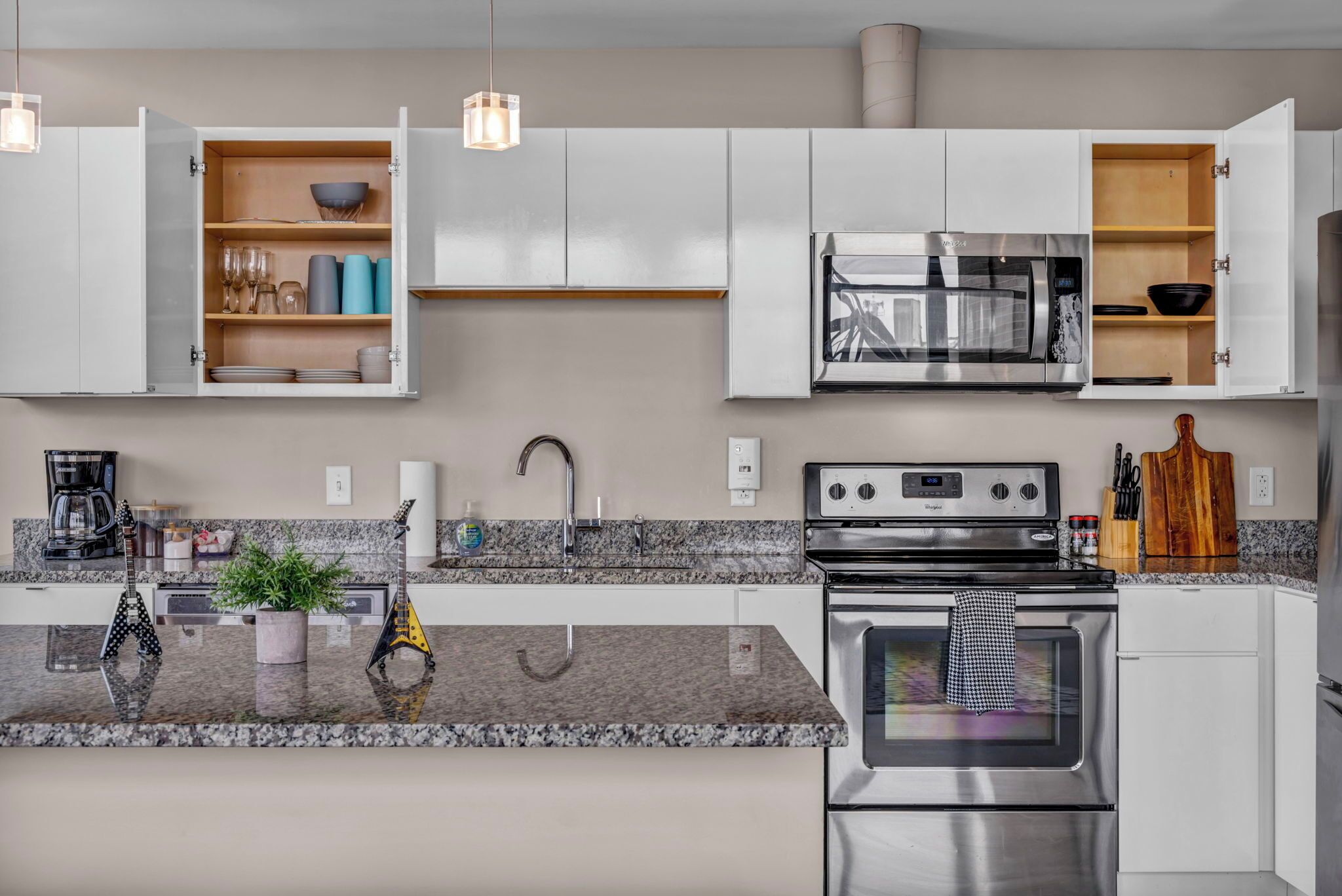 A modern kitchen with white cabinets, a stainless steel oven, and a granite countertop.