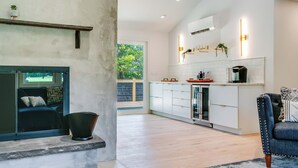 A modern kitchen with white cabinets, a black countertop, and a built-in oven. - New Paltz Modern Zen Cabin (New Paltz)