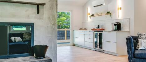 Una cocina moderna con armarios blancos, encimera negra y horno empotrado.