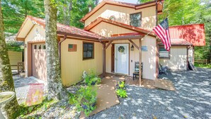 A two-story house with a front porch, a flag, and a small garden. - Community Perks! 'Mtn Serenity Retreat' in Newland (Newland)