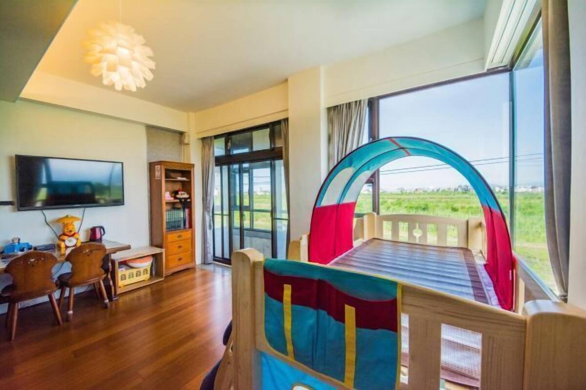 Una habitación con una cama, televisión, escritorio y ventana con vistas.