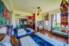 A room with two beds, a sofa, a wooden floor, and a view of the outdoors. - Husband Wife Friendly Bed and Breakfast (Yilan)